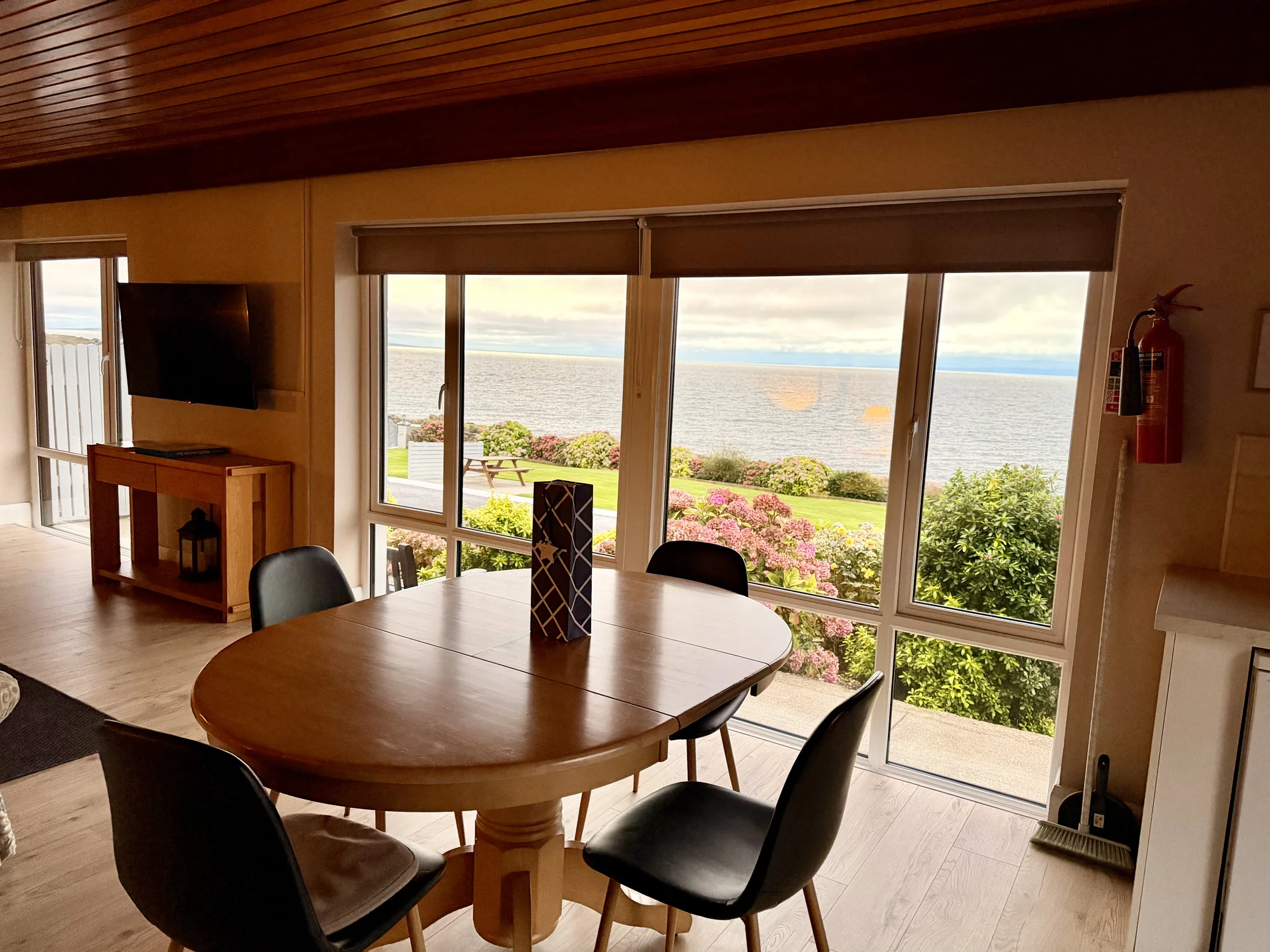 Dining table beside the sea-facing windows at Dolphin House