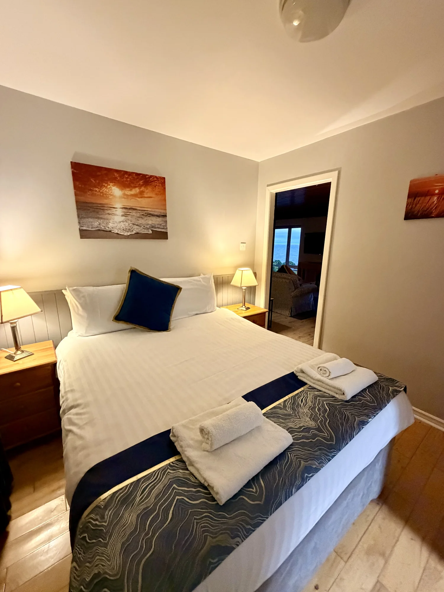 Double bedroom with blue cushions and folded towels at Dolphin House