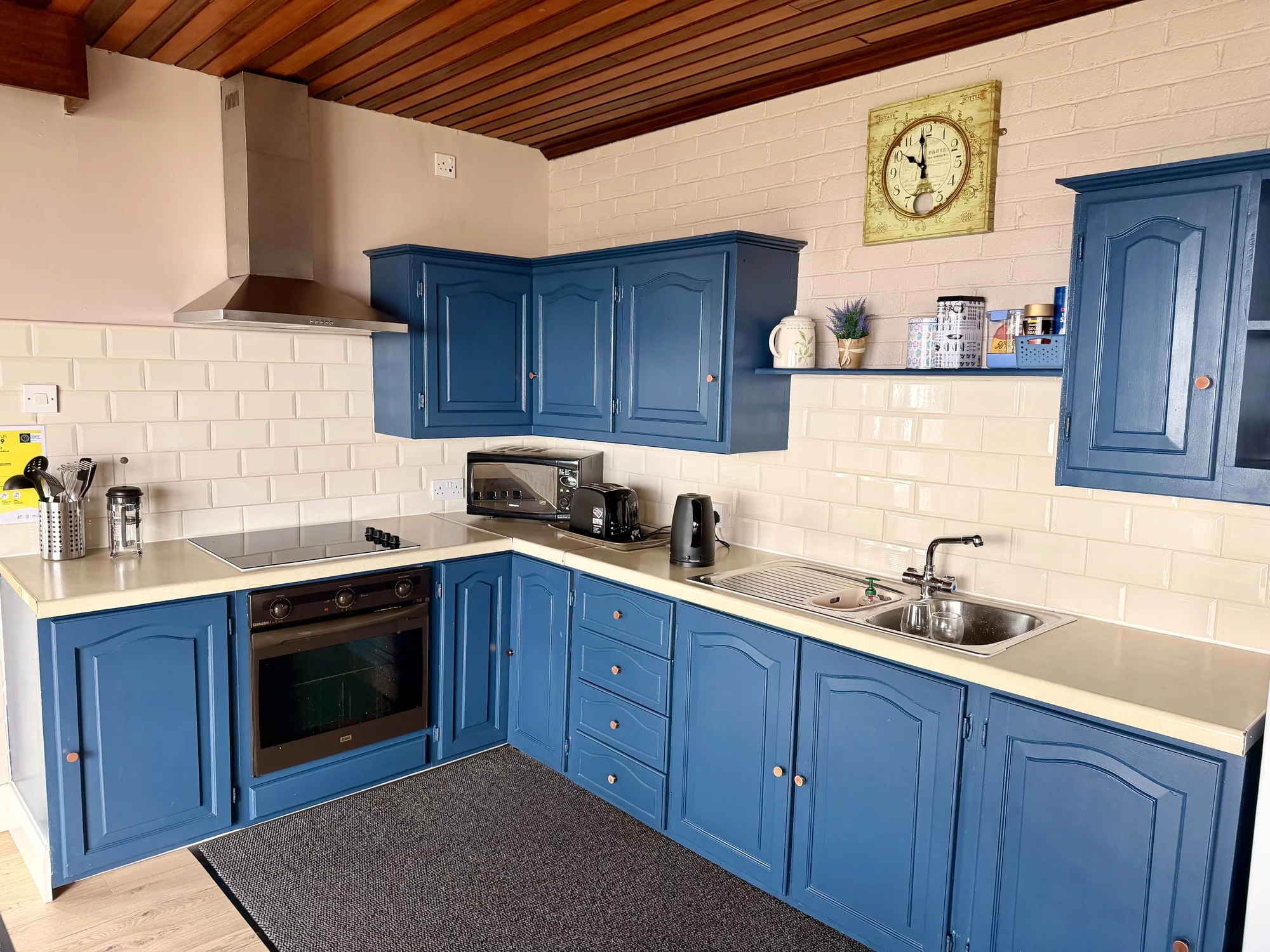 Blue kitchen with oven, hob and sink at Dolphin House