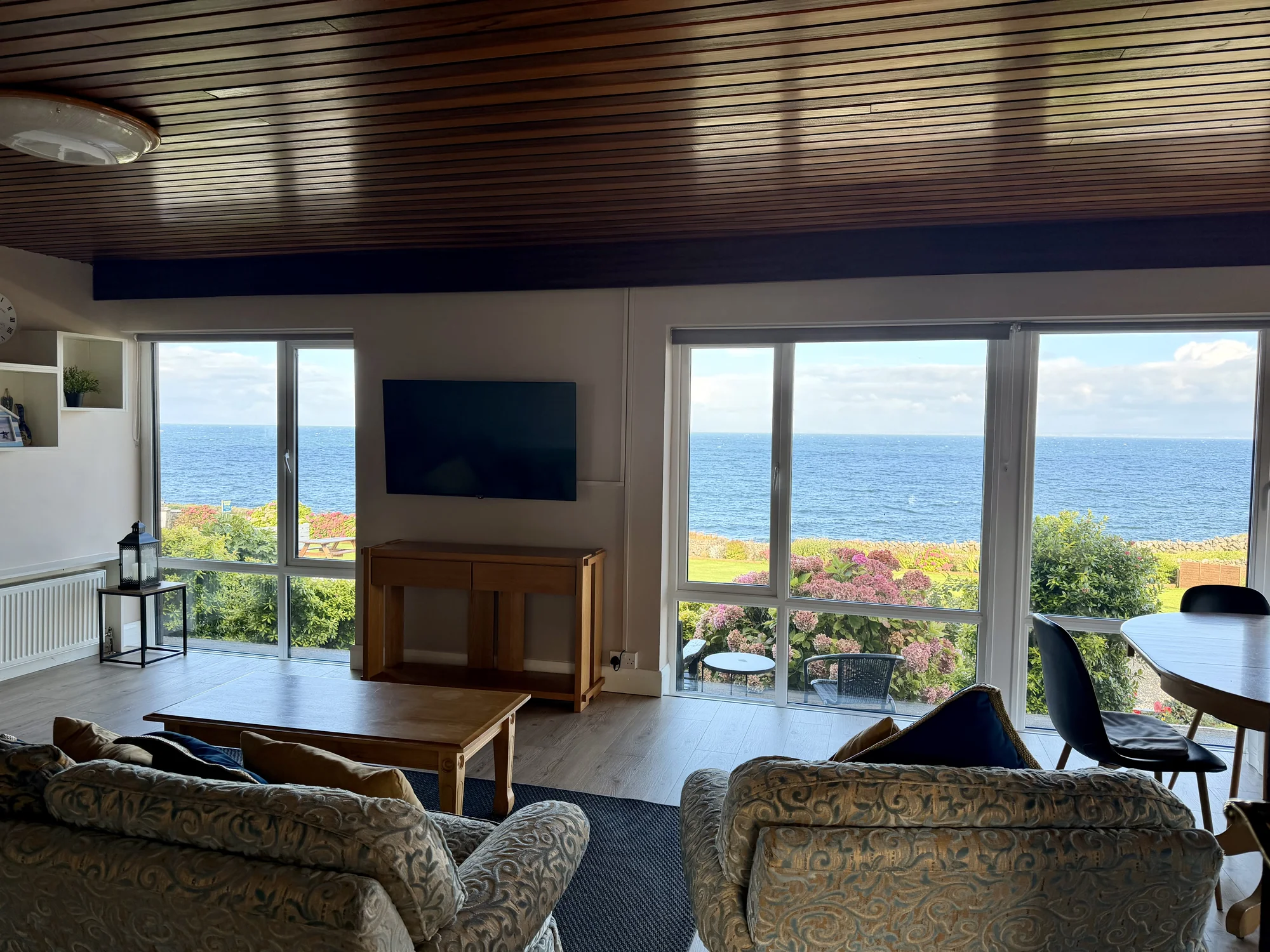 Living room looking out across the garden towards the sea at Dolphin House