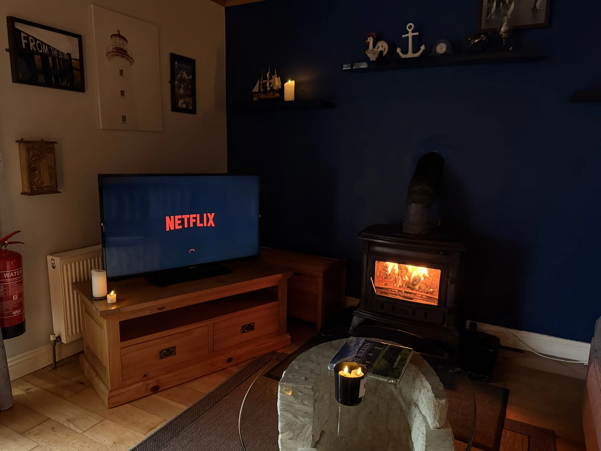 Television and glowing stove in the living area at Sailor’s Cabin