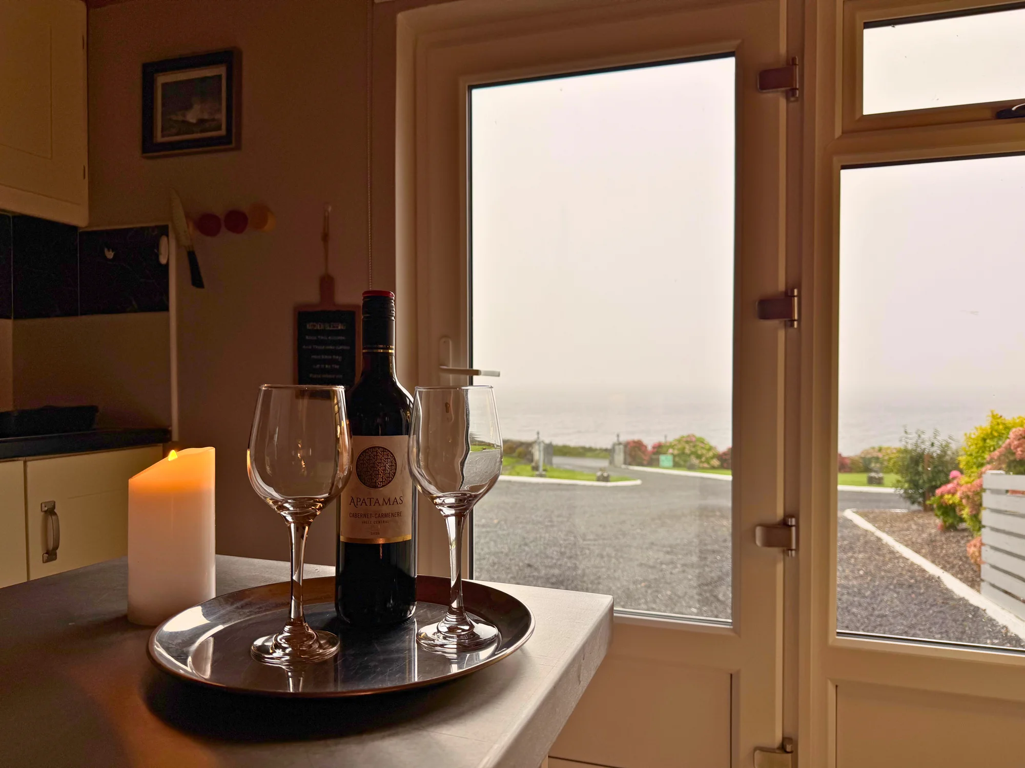 Wine glasses beside the sea-facing doors at Sailor’s Cabin